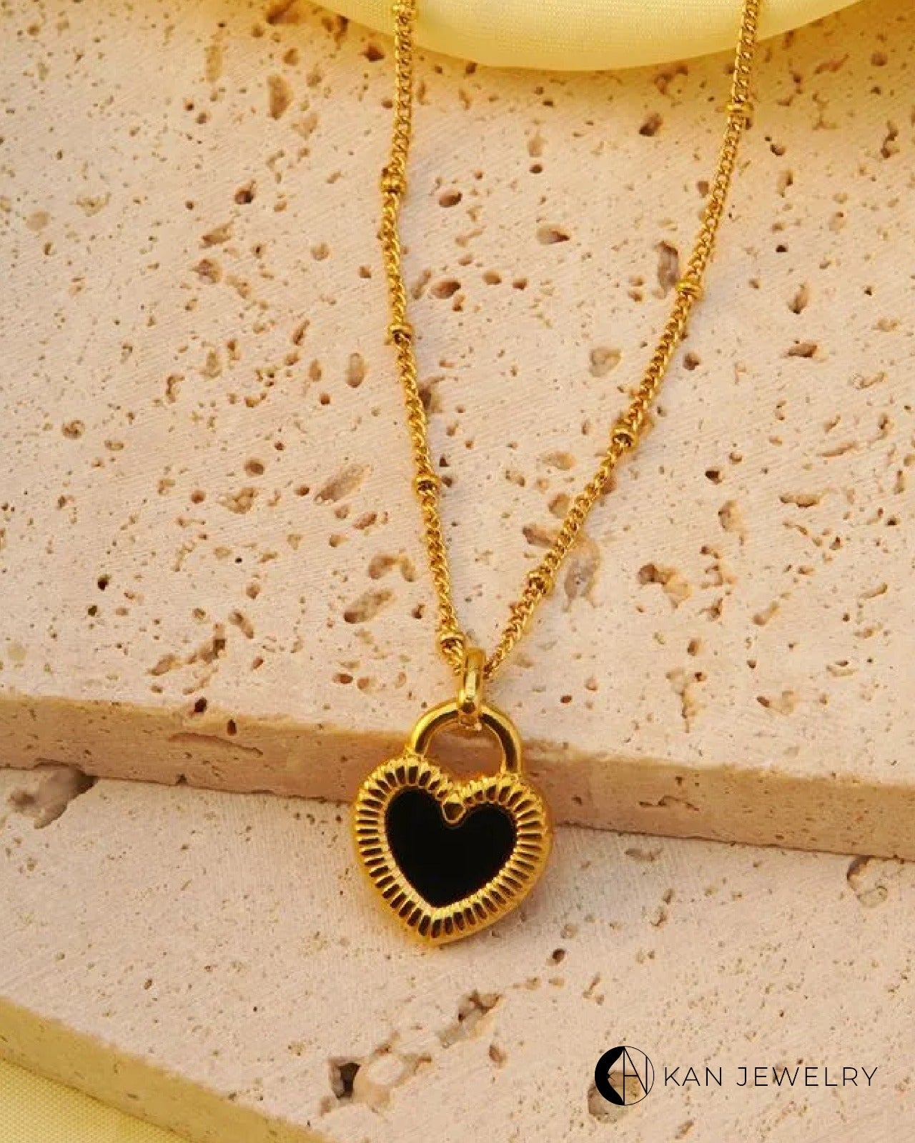 Collar de corazón negro acero con baño de oro